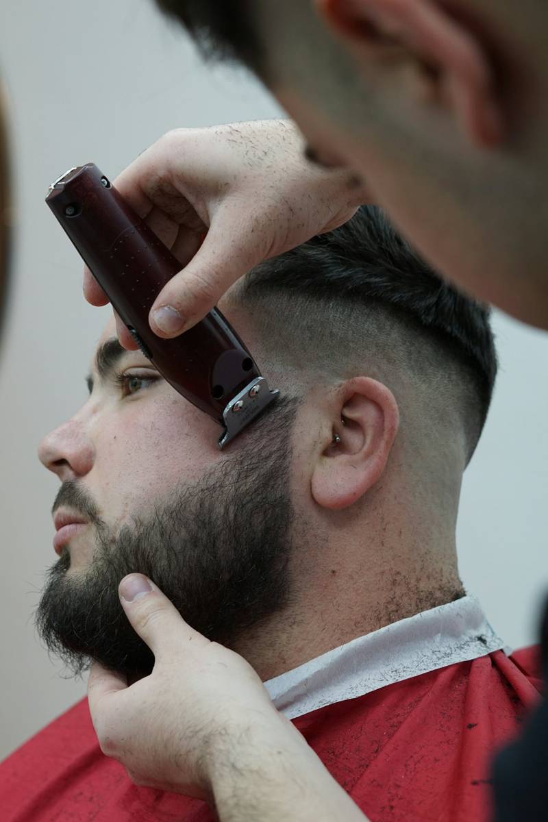 Barber lining up a client’s beard with a trimmer