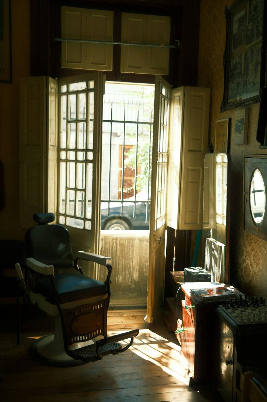 Empty barber chair beside a sunlit doorway