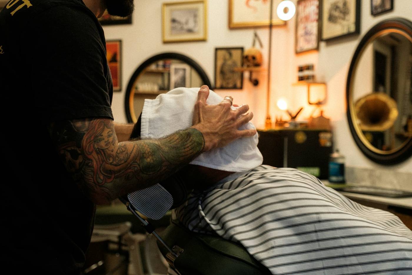 Barber wrapping a client in a hot towel