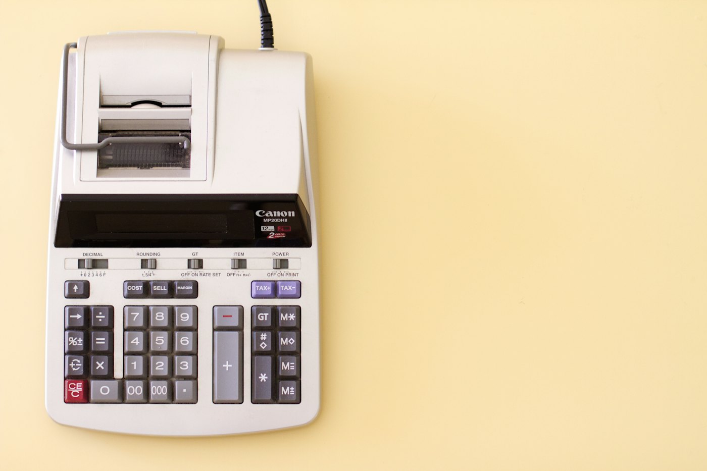 A printing calculator on a bright yellow desk