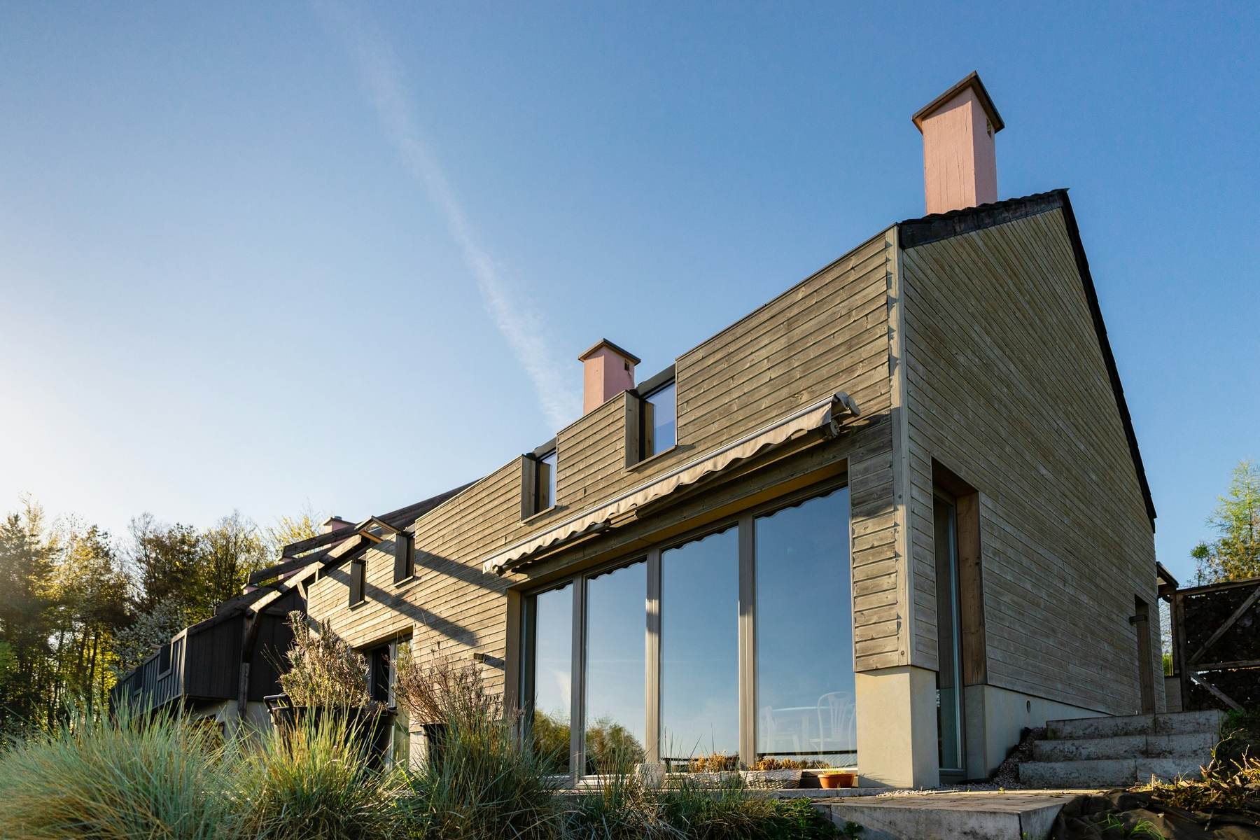 Gabled timber and stone house with a tall glass wall