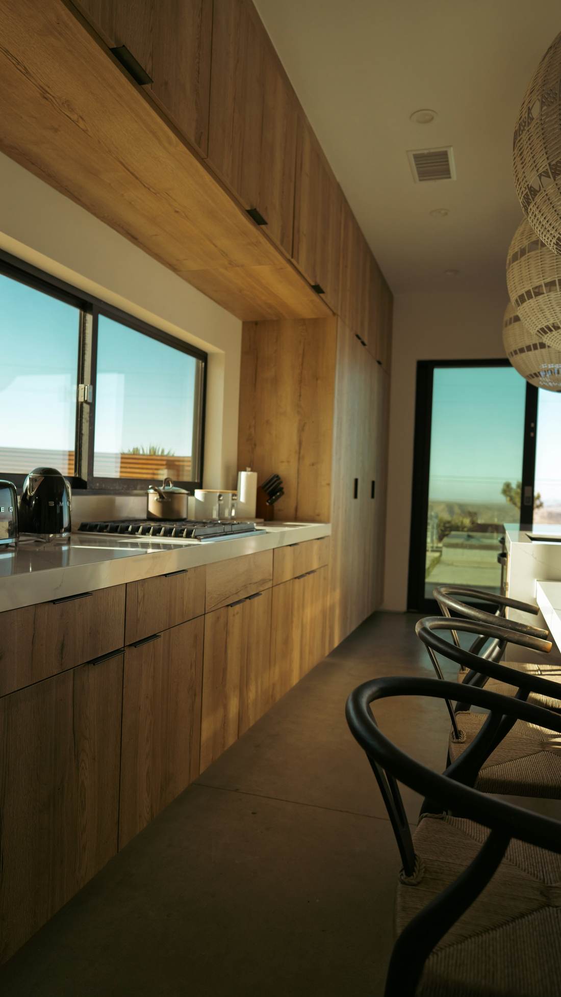 Long timber galley kitchen ending at a wide window