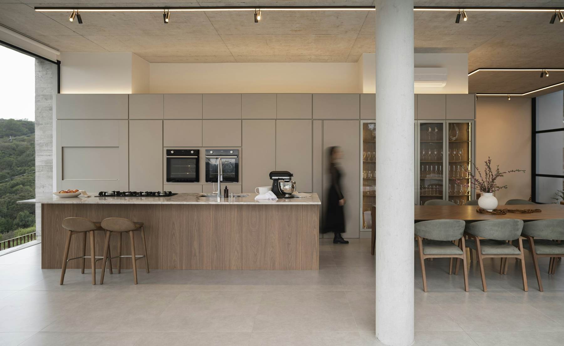 Kitchen and dining space in the Cedar House with a timber island and pale cabinetry