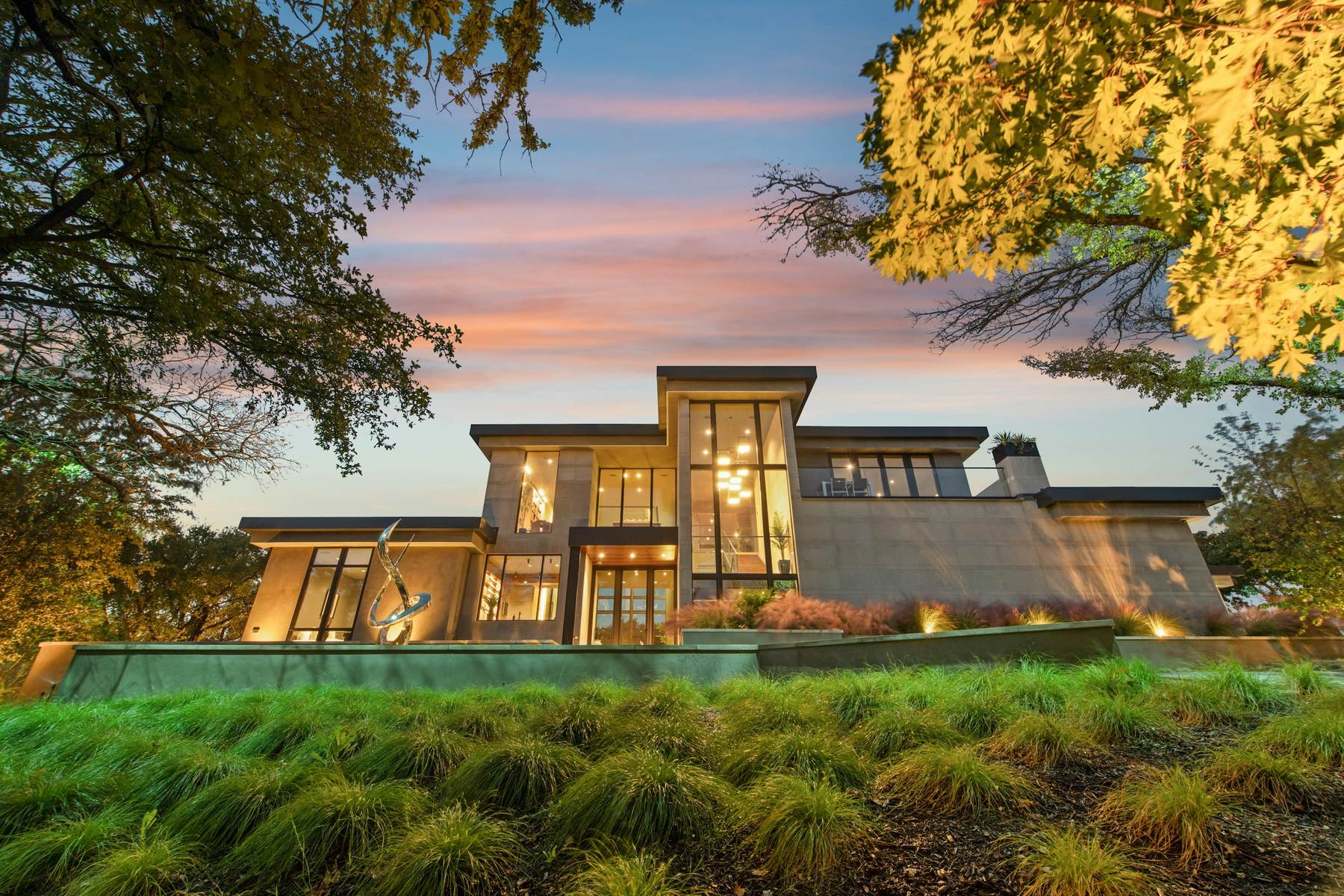 Low modern house at sunset behind meadow grasses