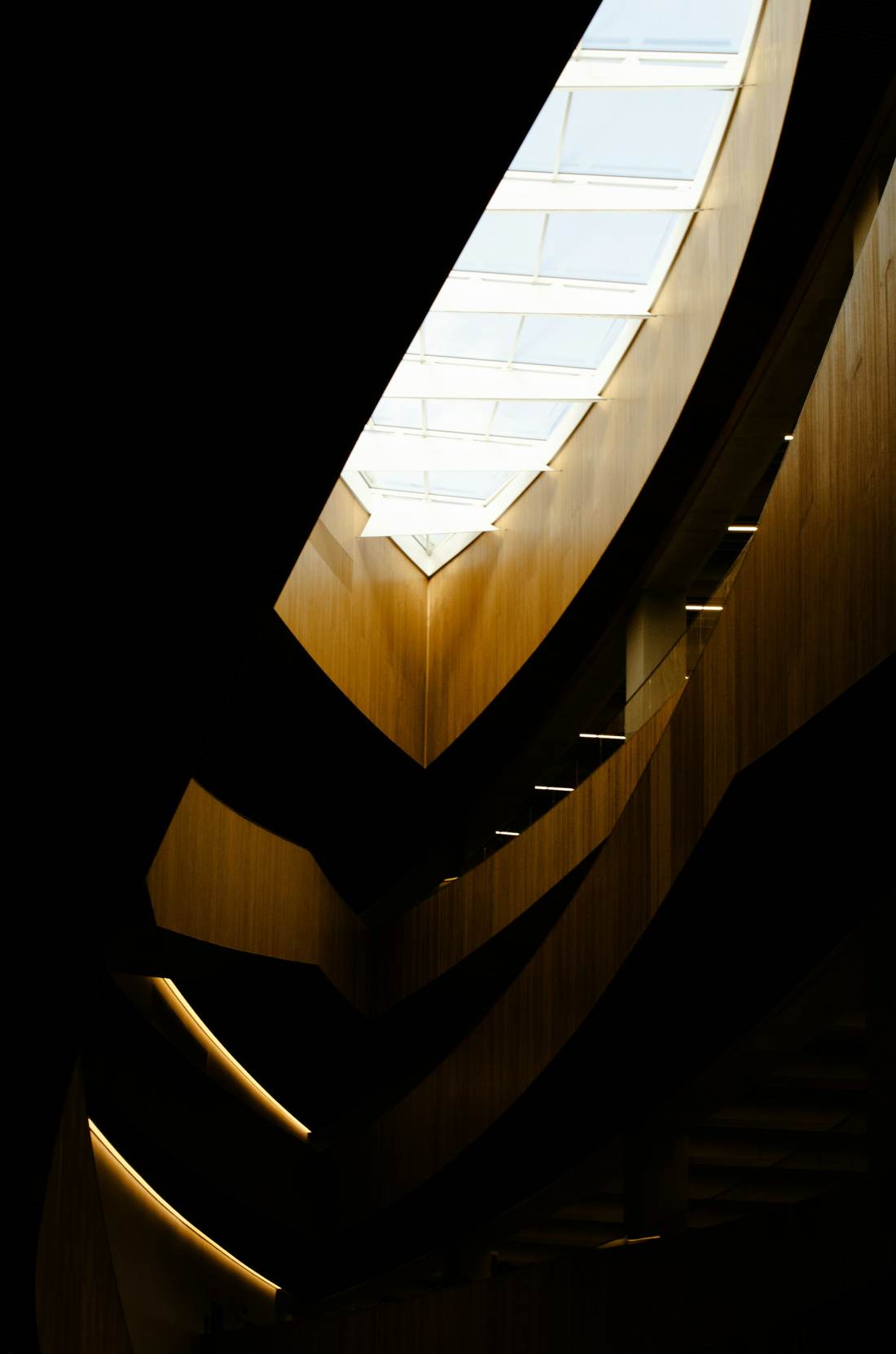 A curved stair lit from a skylight above