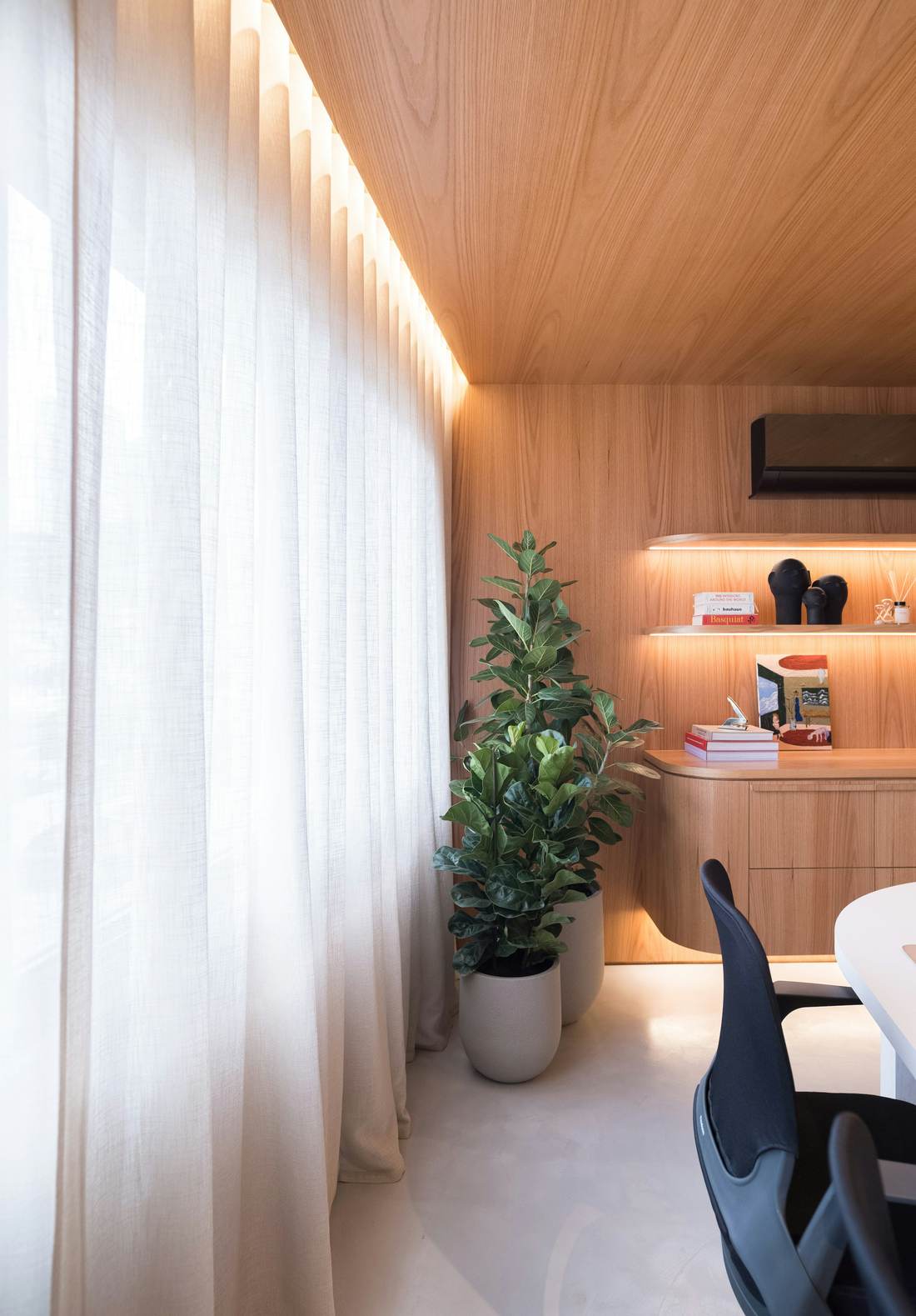 Calm living room with timber walls, a soft sofa and tall windows