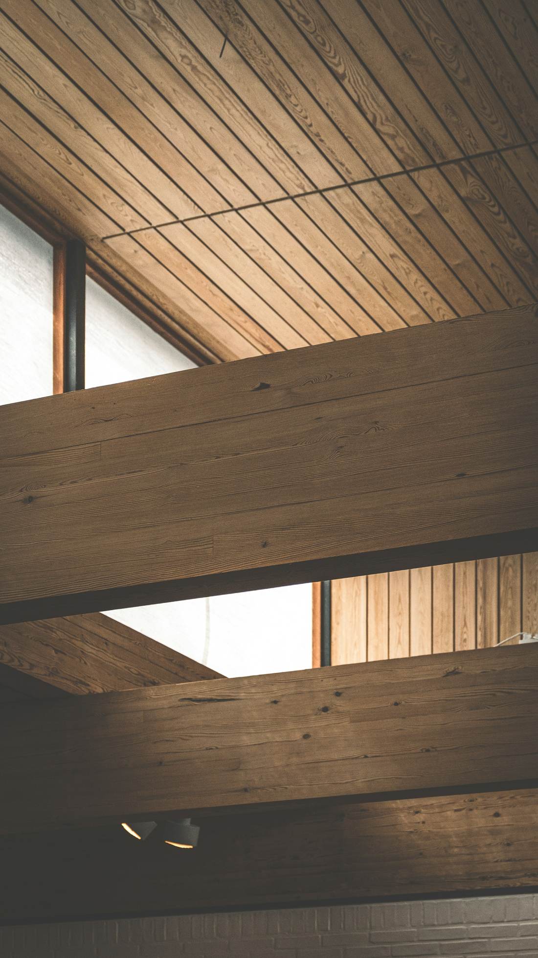 Timber ceiling boards running out past a window
