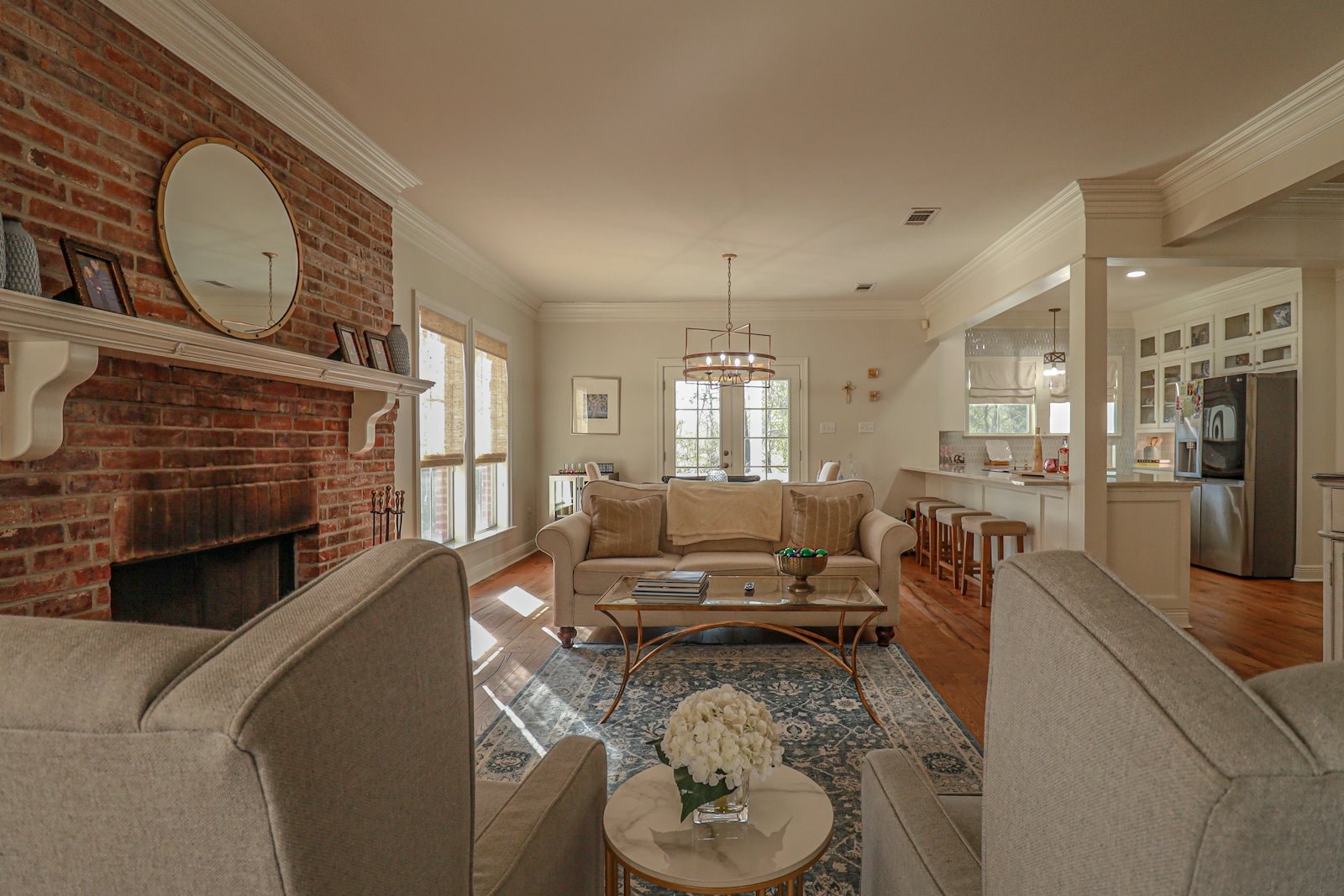 Warm living room with a brick fireplace and soft chairs