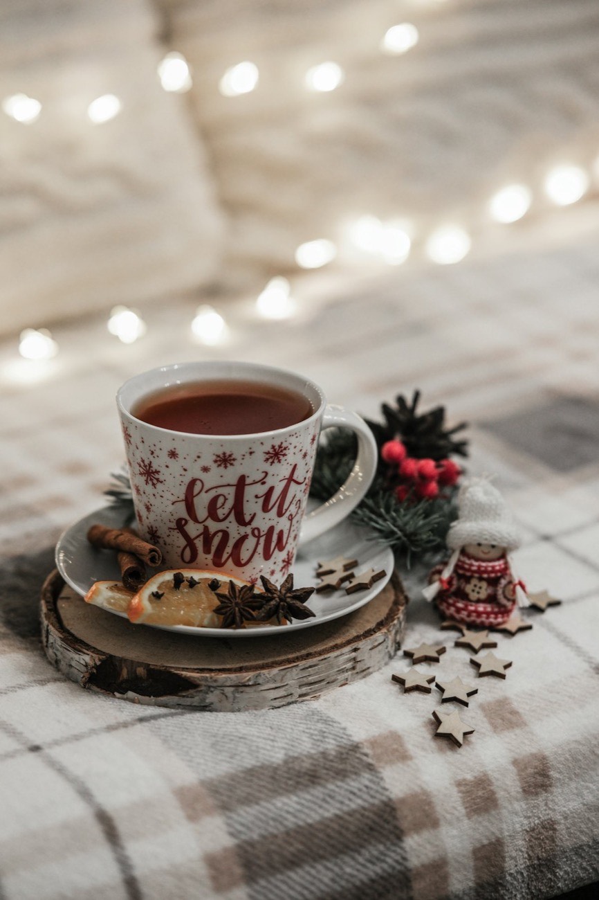 Cup of tea on a plaid blanket with twinkle lights