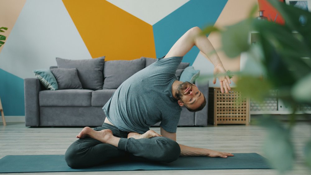 Daniel Reyes stretching to the side on a mat in a bright room