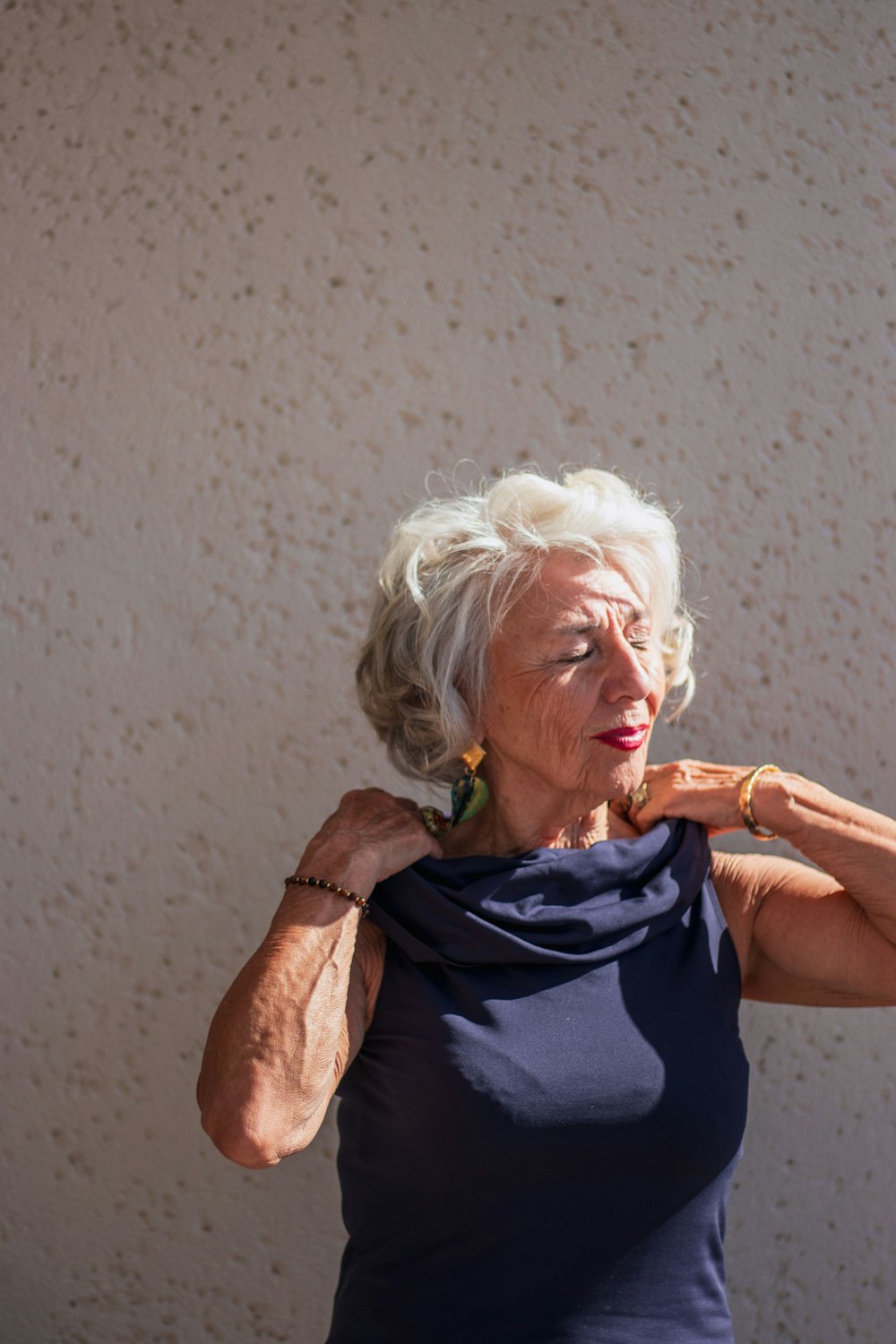 A woman with silver hair rolling her shoulders