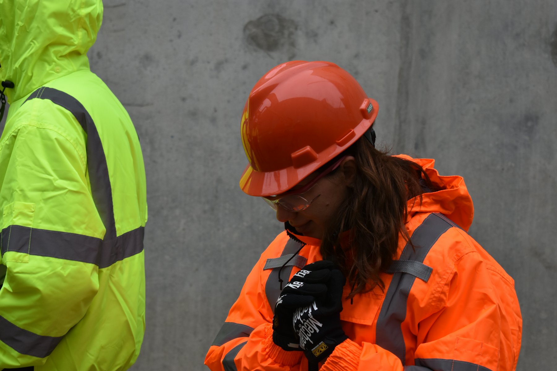 Two crew members in hard hats and hi-vis jackets on site