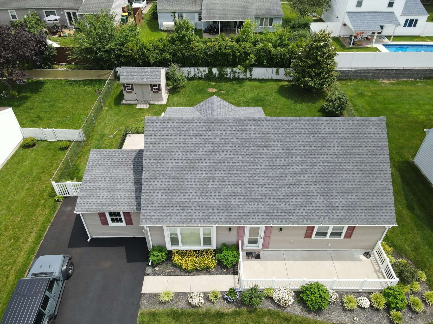 Aerial view of a suburban home with a grey shingle roof