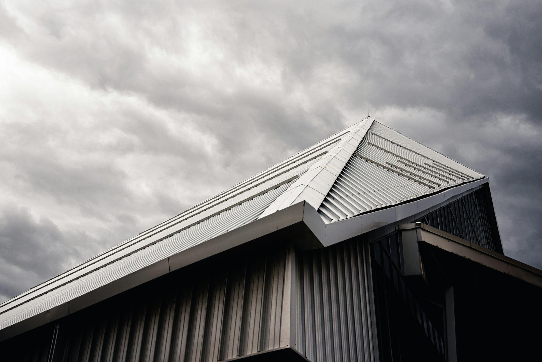 Standing seam metal roof under a dramatic grey sky