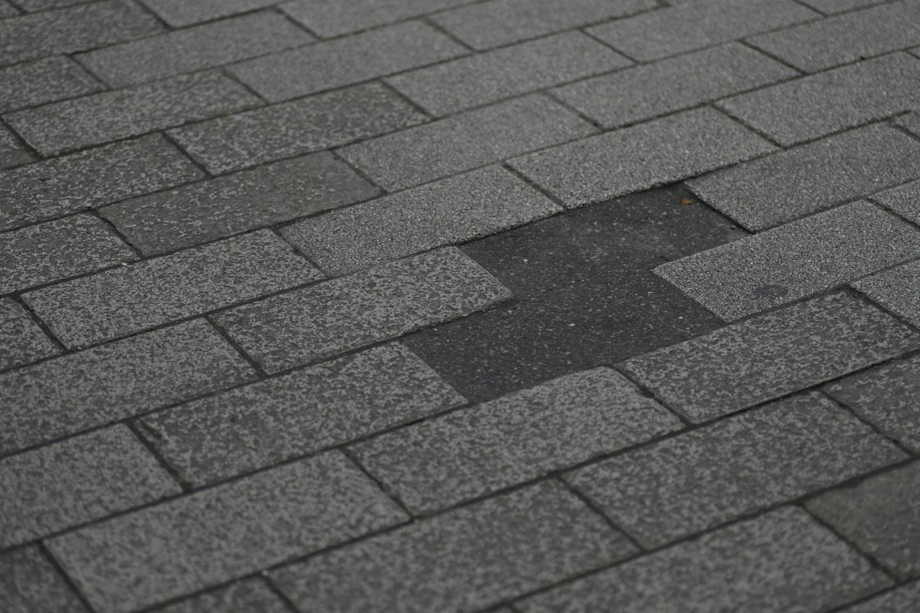 Shingle roof with storm damage and missing pieces