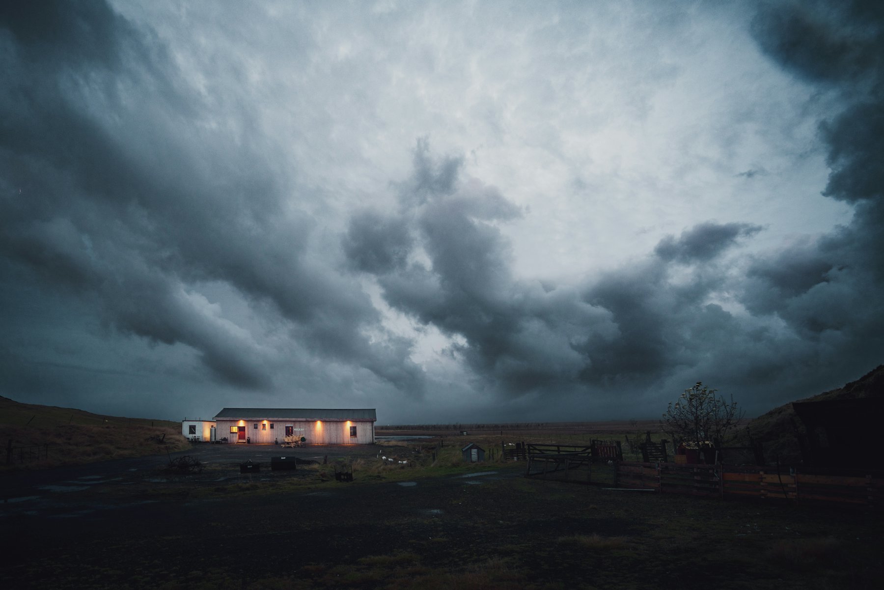 Heavy storm clouds over a house on a dark field