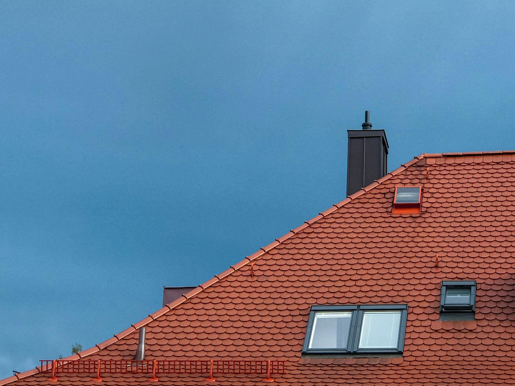 Red clay tile roof against a blue sky