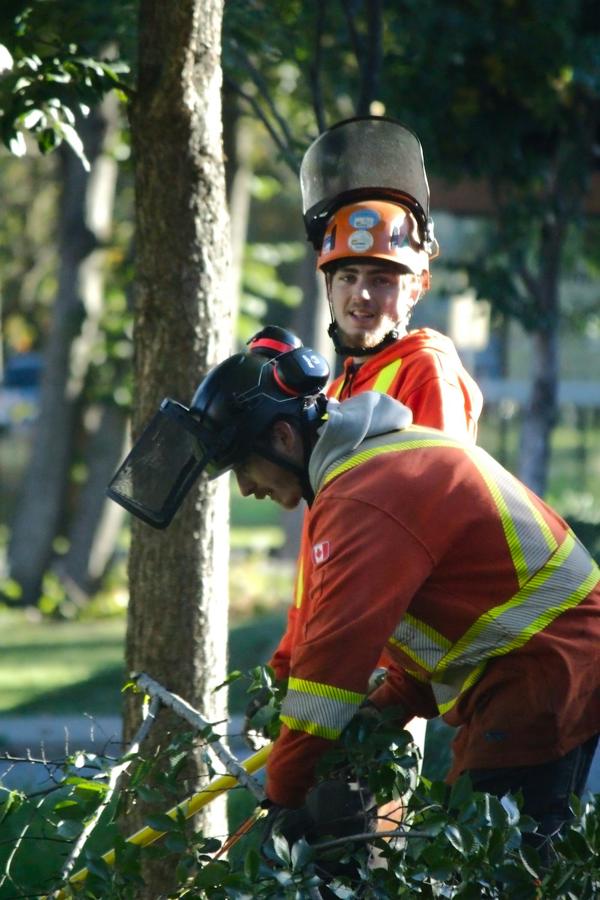 A smiling climber in an orange helmet and hi-vis jacket